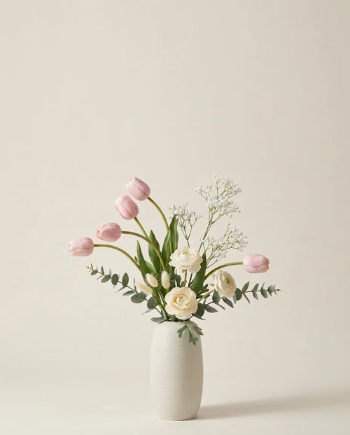 Bouquet artificiel de tulipes, renoncules et lagurus rose et blanc dans un vase en céramique
