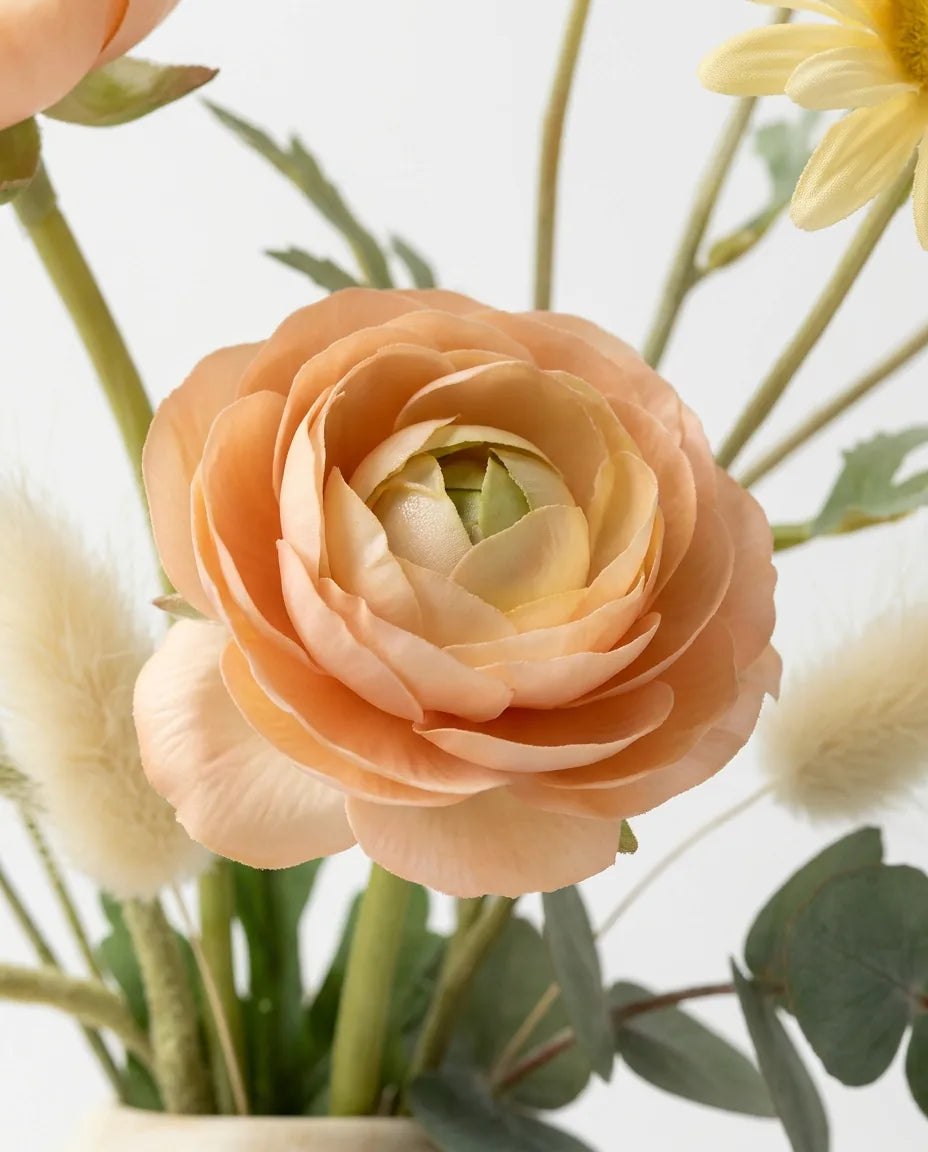 Gros plan sur les renoncules artificielles du bouquet Réveil du Jardin