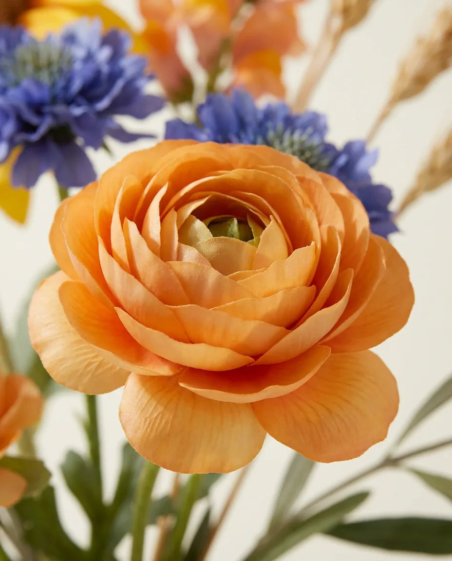 Gros plan sur les renoncules artificielles du bouquet Midi d'Été