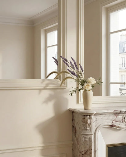 Bouquet artificiel violet et blanc sur une cheminée en marbre dans un salon parisien