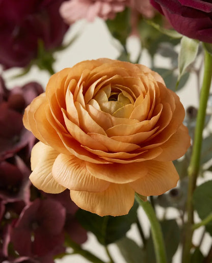 Gros plan sur les renoncules artificielles du bouquet Vendanges
