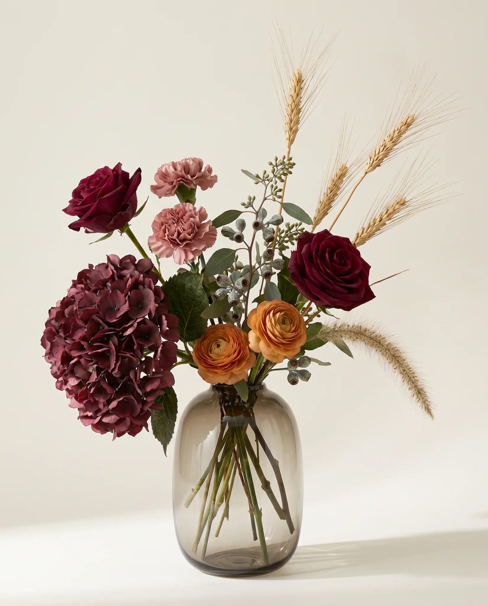 Bouquet artificiel de roses, hortensias et œillets rouge et rose en gros plan