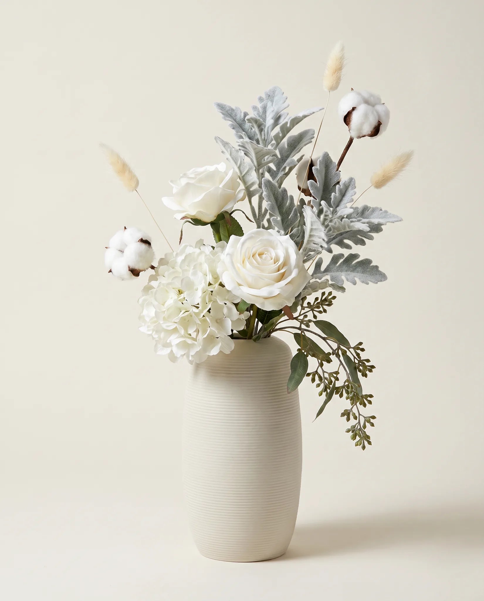 Bouquet artificiel de roses, hortensias et cinéraire blanc et vert en gros plan