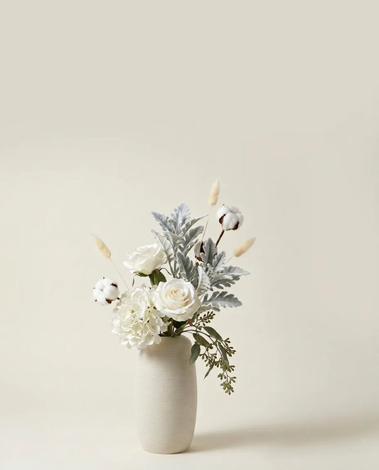 Bouquet artificiel de roses, hortensias et cinéraire blanc et vert dans un vase en céramique