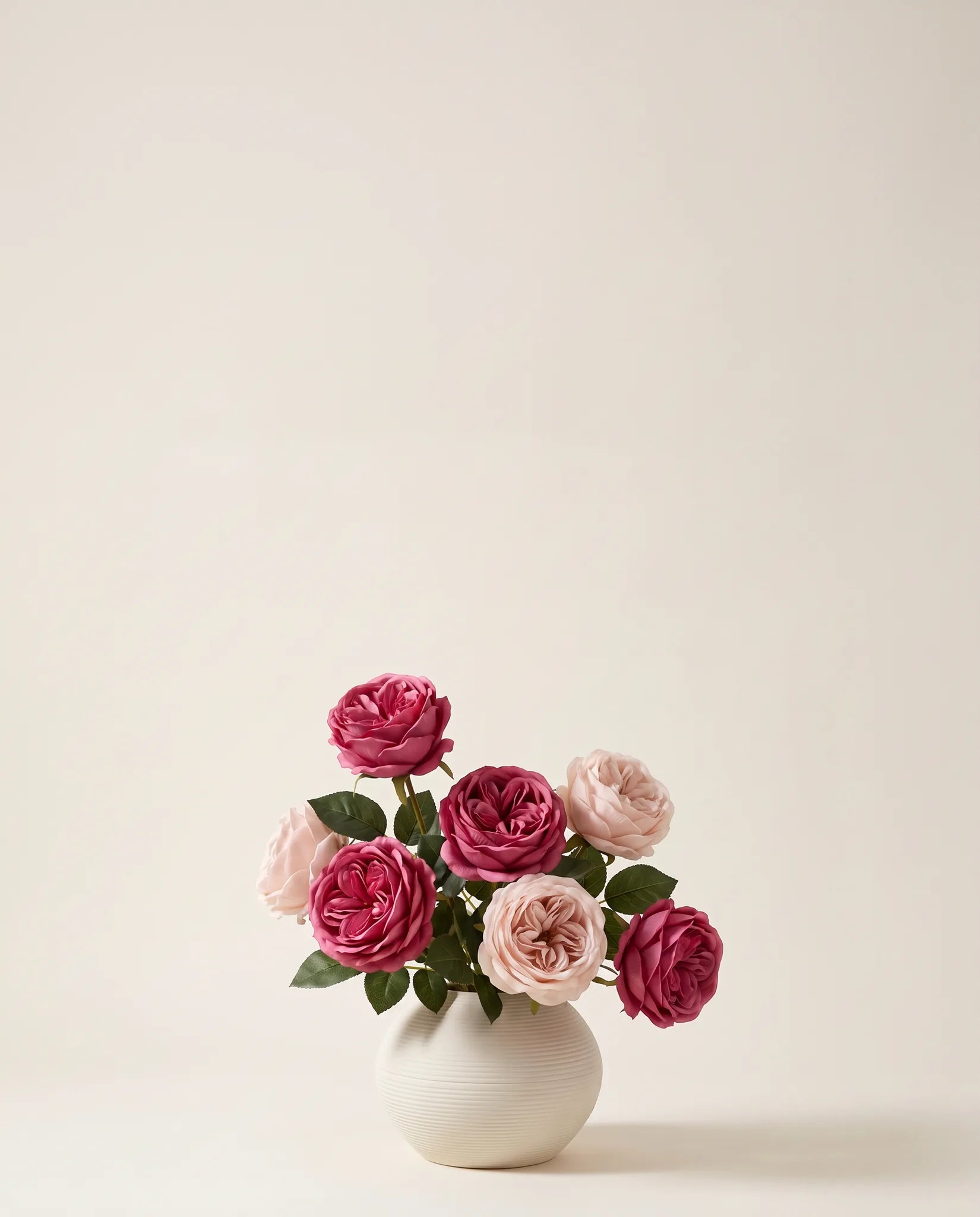 Bouquet artificiel de roses rose magenta dans un vase en céramique