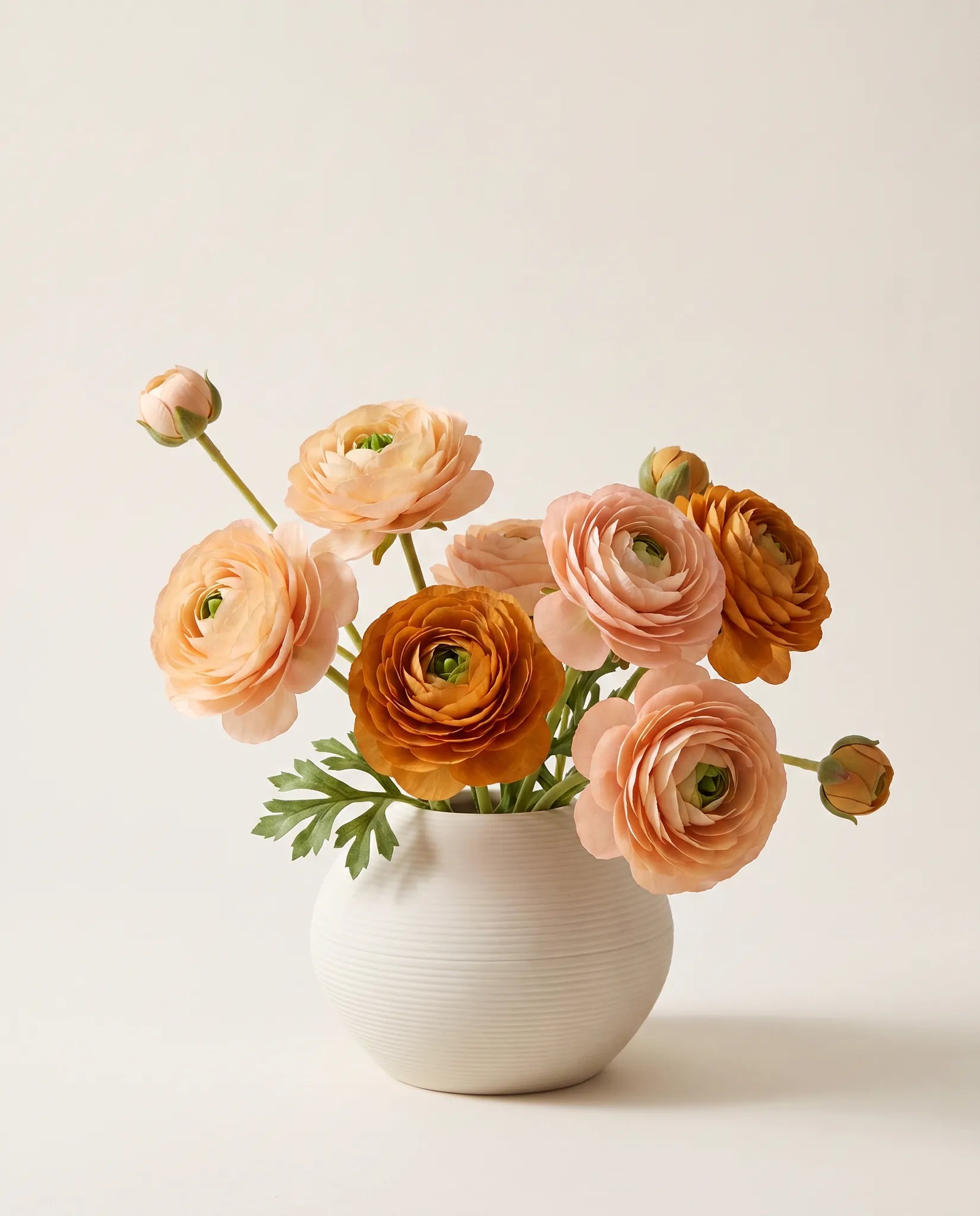Bouquet artificiel de renoncules rose abricot et orange caramel en gros plan