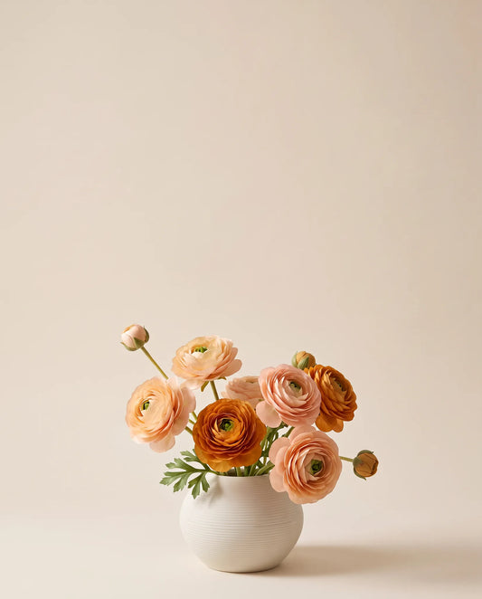 Bouquet artificiel de renoncules rose abricot dans un vase en céramique