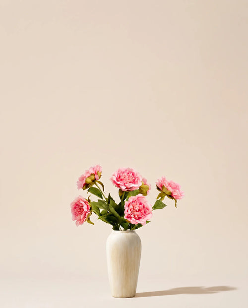 Bouquet artificiel de pivoines rose tendre dans un vase en céramique