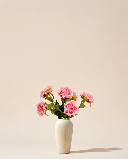 Bouquet artificiel de pivoines rose tendre dans un vase en céramique