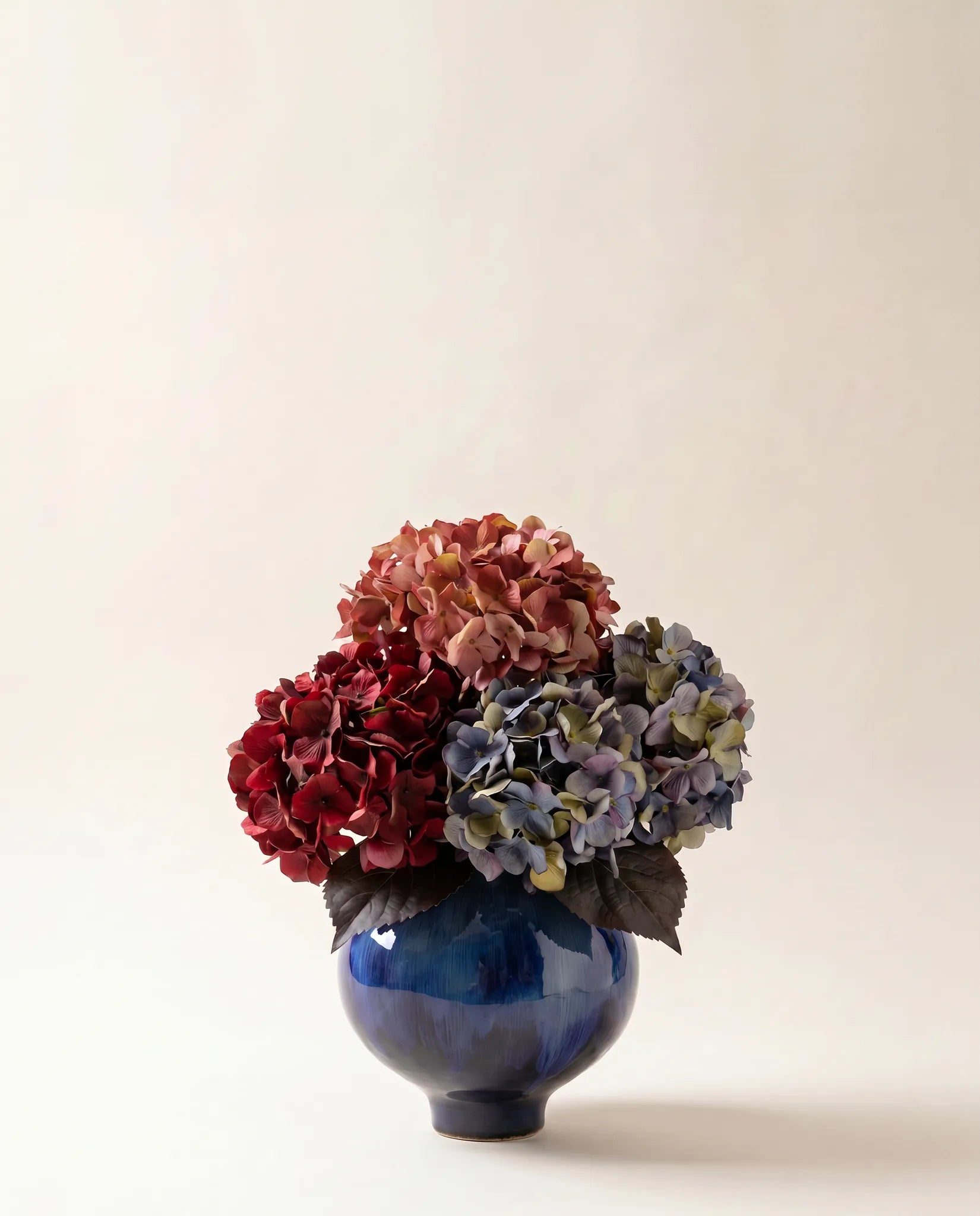 Bouquet artificiel d'hortensias rose et bleu dans un vase en céramique