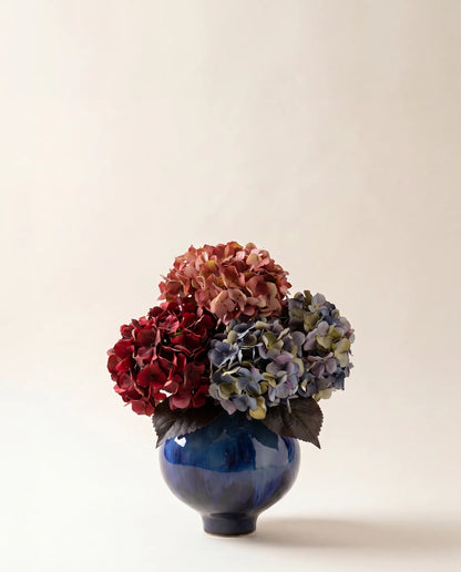 Bouquet artificiel d'hortensias rose et bleu dans un vase en céramique
