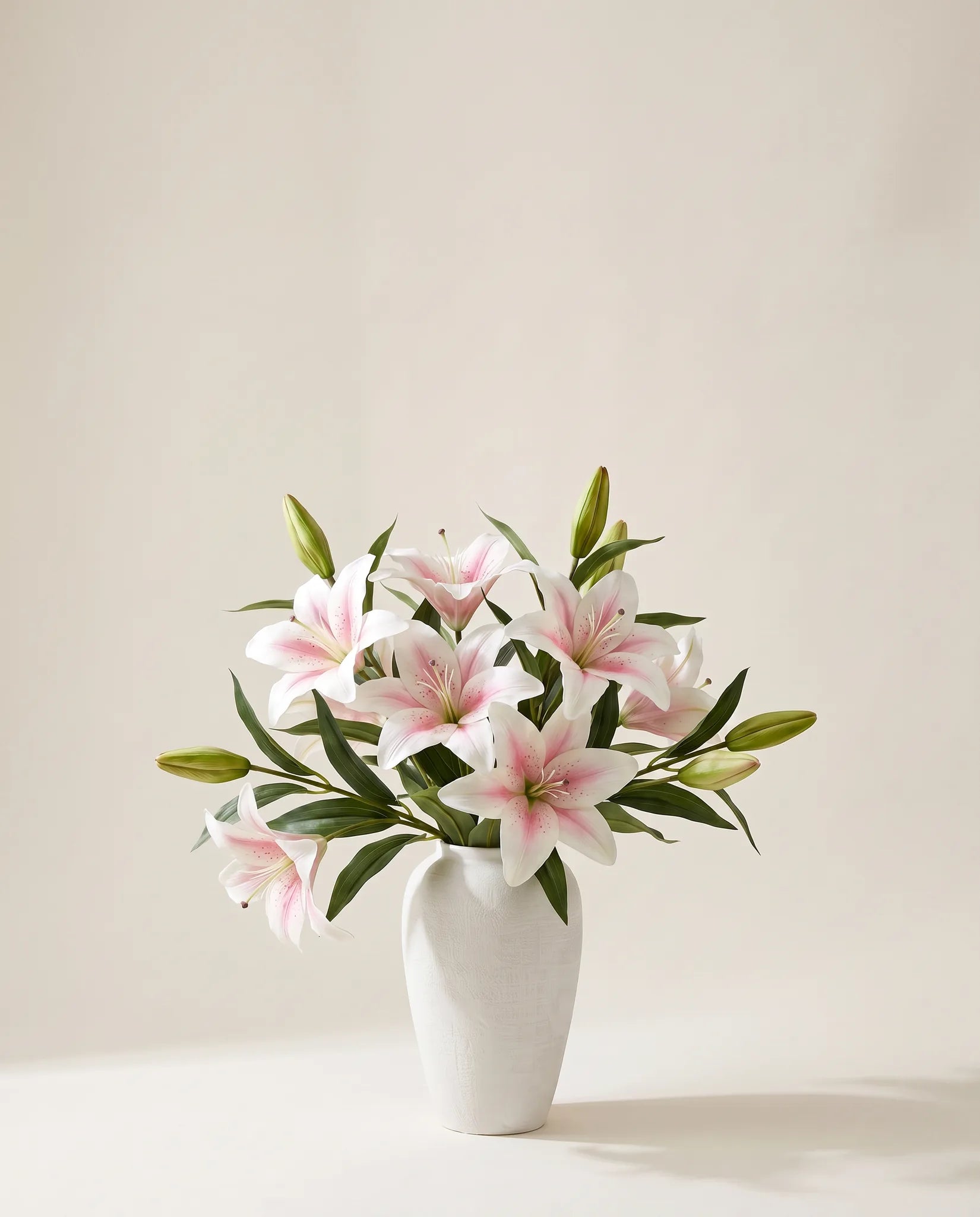 Bouquet artificiel de lys blancs dans un vase en céramique