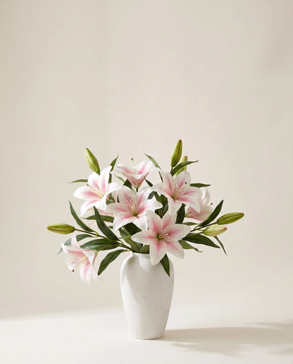 Bouquet artificiel de lys blancs dans un vase en céramique