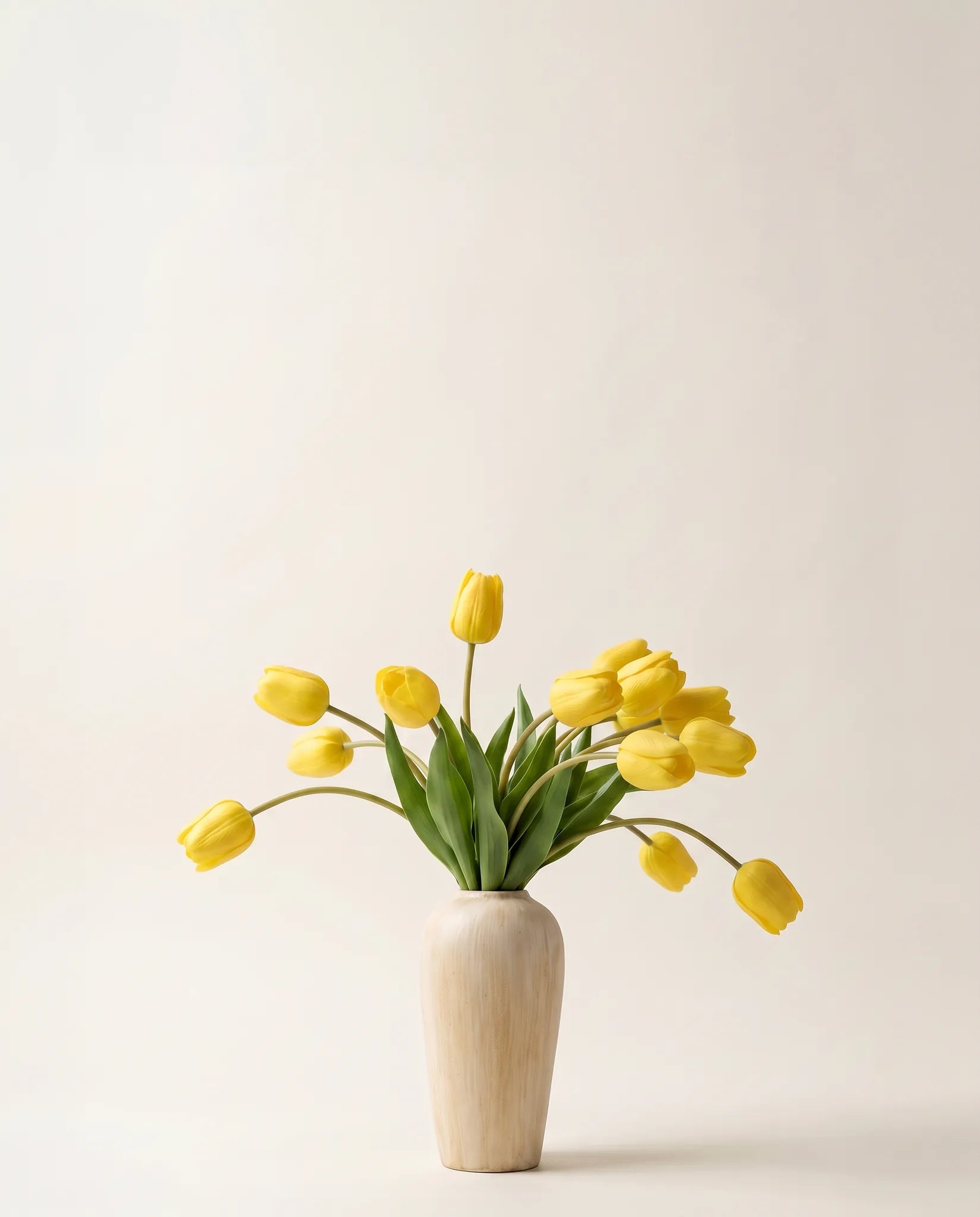 Bouquet artificiel de tulipes jaune vif dans un vase en céramique
