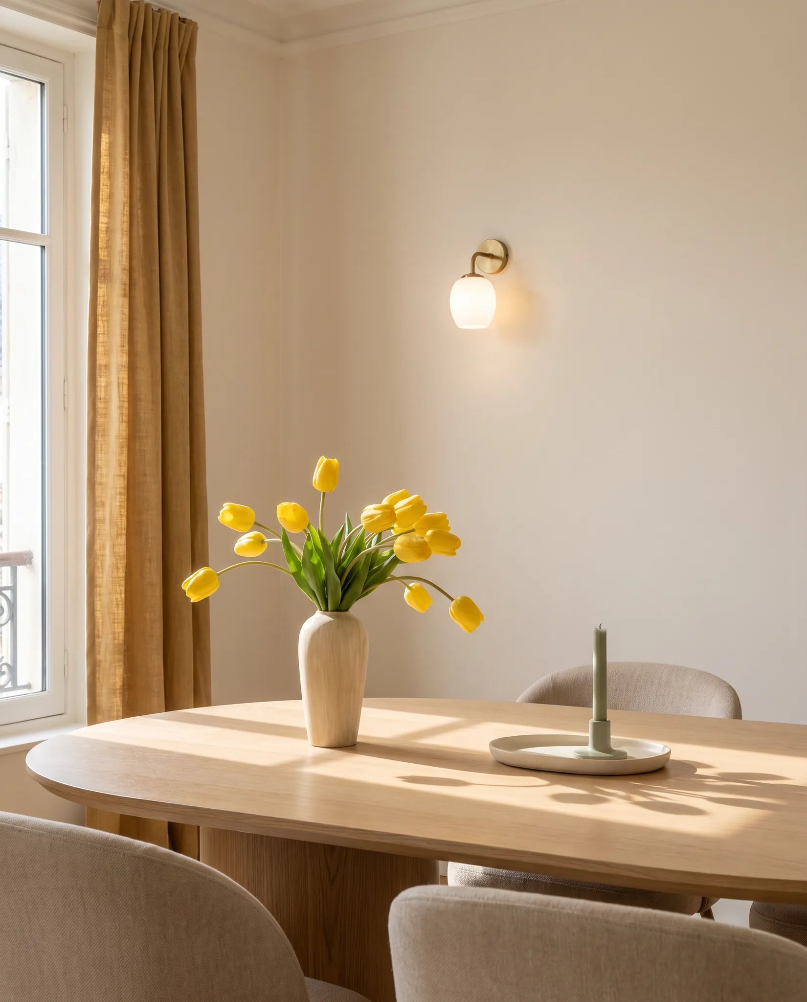 Bouquet artificiel jaune vif sur une table ovale en chêne clair, salle à manger