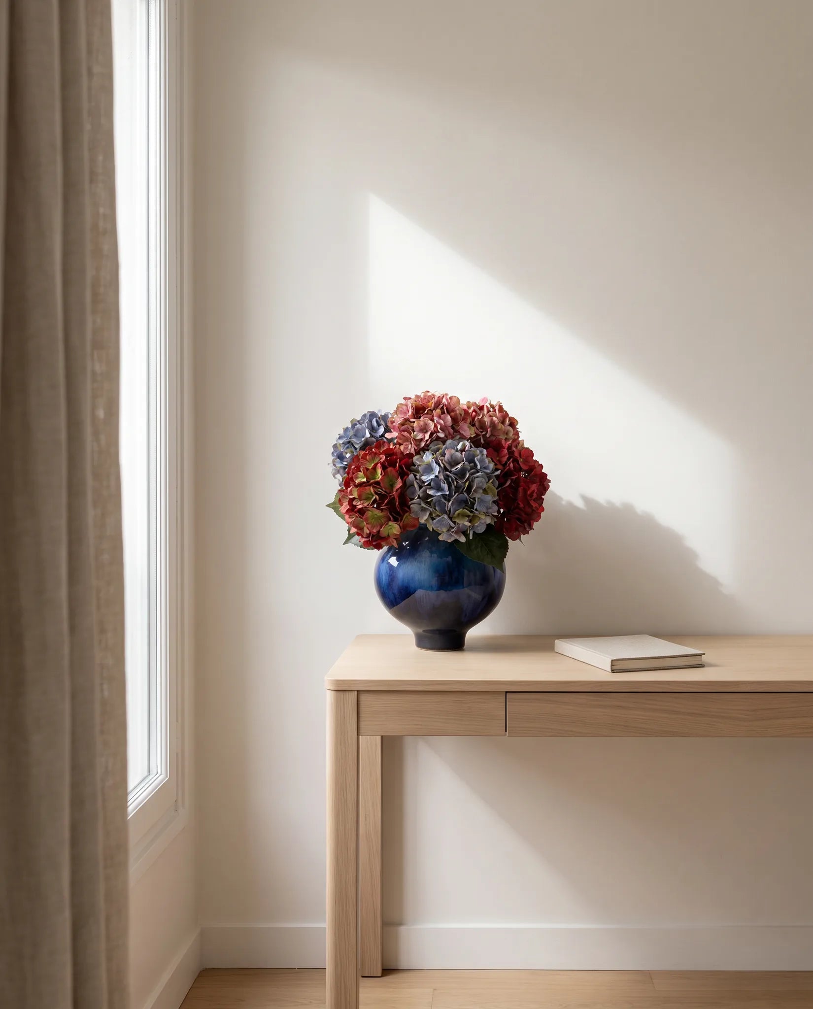 Bouquet artificiel aux tons fanés sur la table en chêne clair d'un bureau