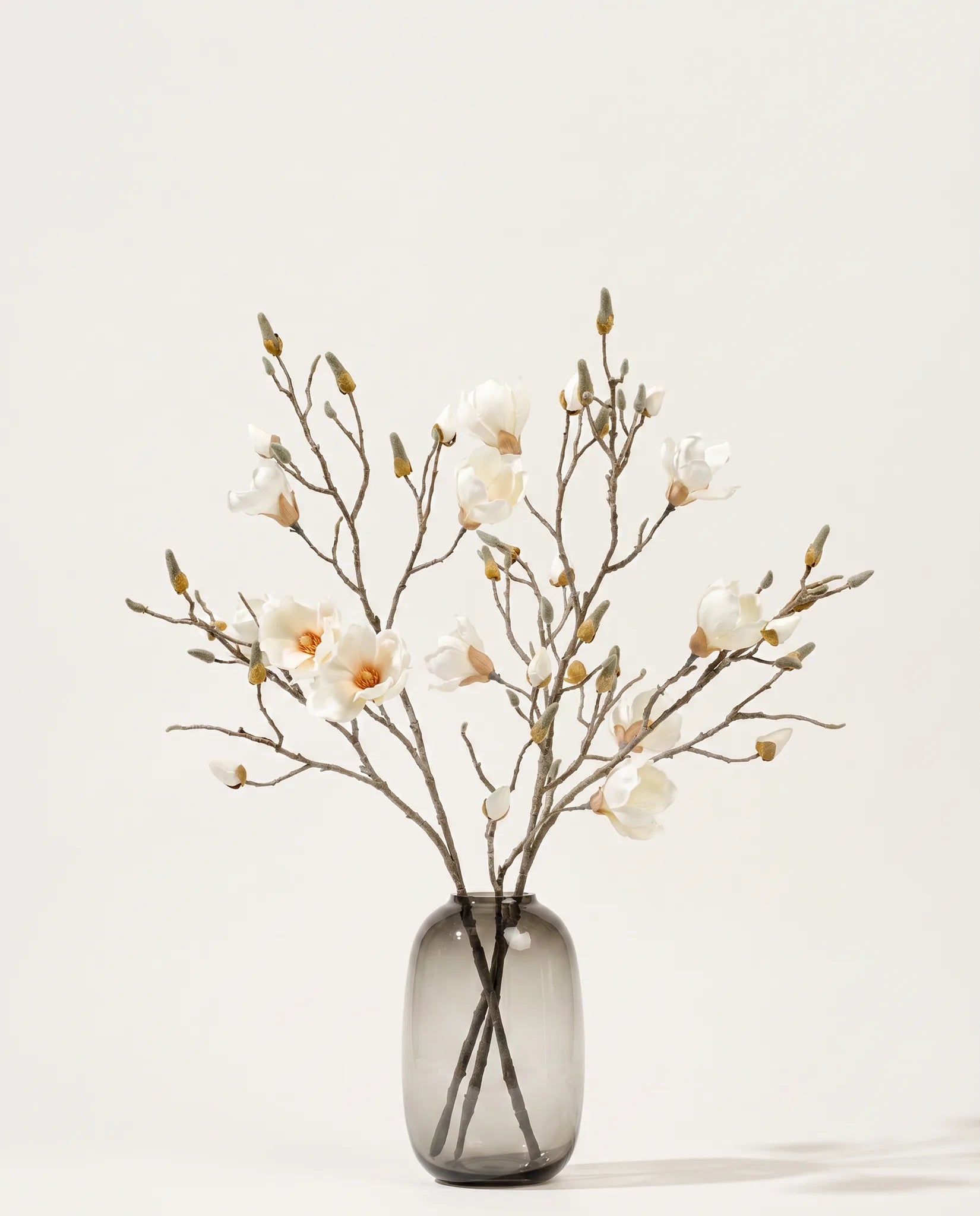 Vase verre ambré mat avec bouquet de magnolia blanc et taupe artificiel