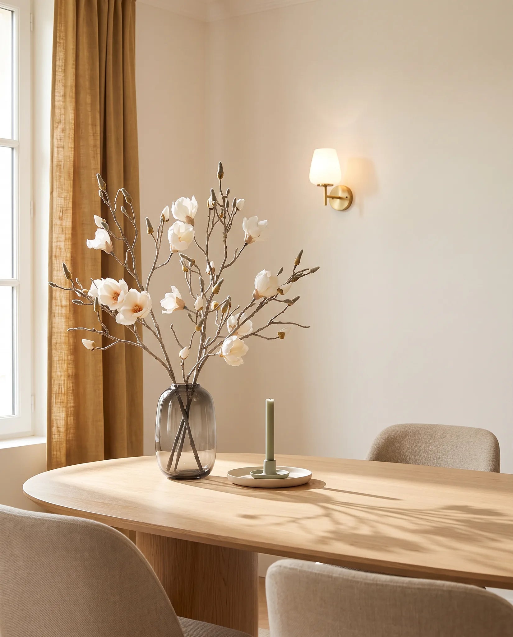 Branches artificielles blanches sur une table ovale en chêne clair, salle à manger