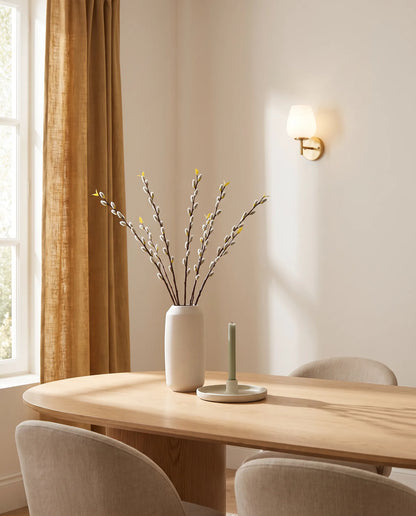 Branches de saule artificielles sur une table ovale en chêne clair, salle à manger