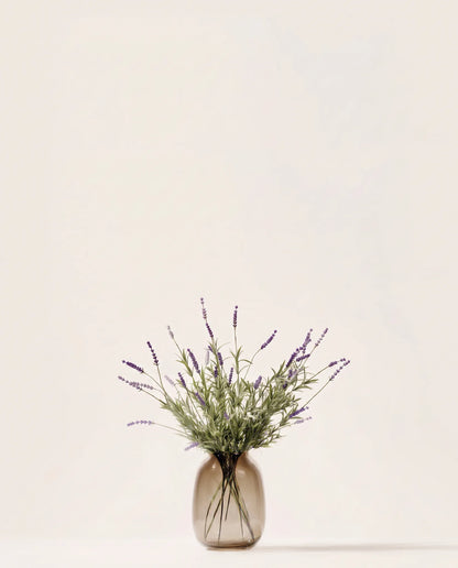 Bouquet artificiel de lavande violette dans un vase en verre ambré