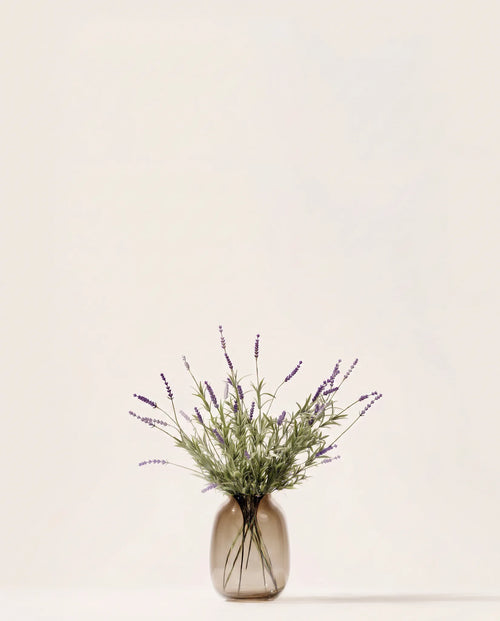 Bouquet artificiel de lavande violette dans un vase en verre ambré