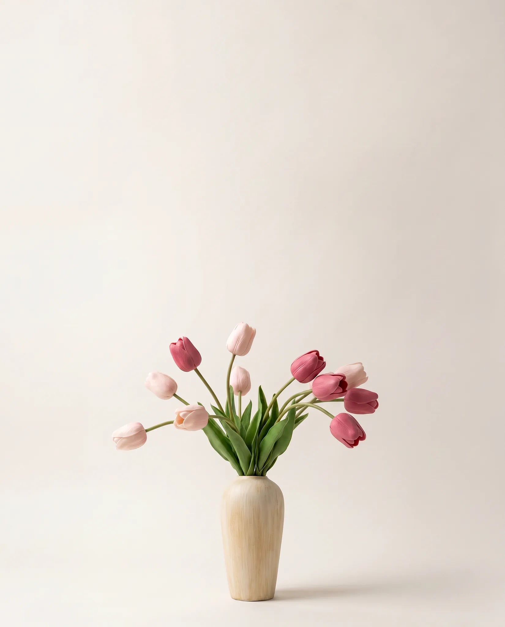 Bouquet artificiel de tulipes roses dans un vase en céramique