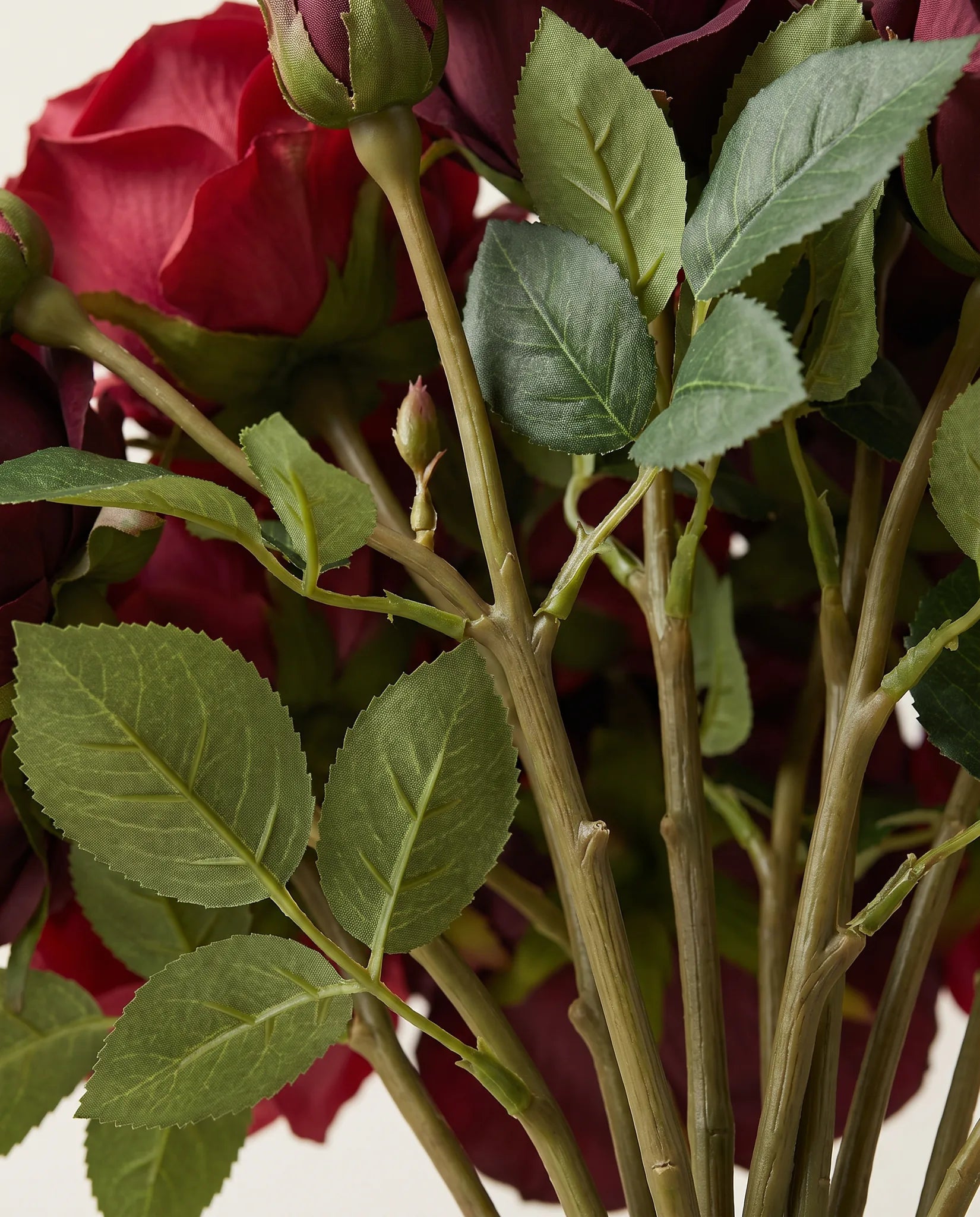 Détail des tiges et du feuillage vert du bouquet artificiel Velours Bordeaux