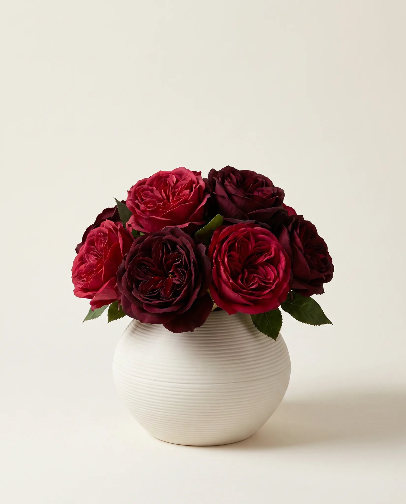 Vase céramique blanc crème strié avec bouquet de roses bordeaux artificielles