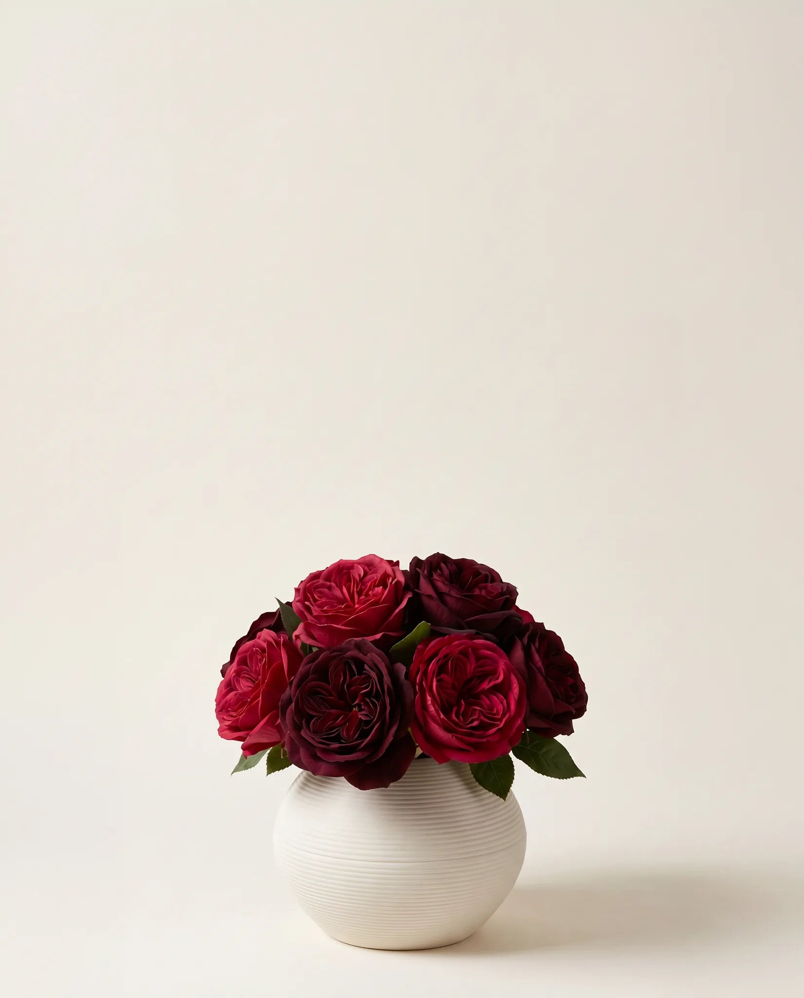 Bouquet artificiel de roses bordeaux dans un vase en céramique