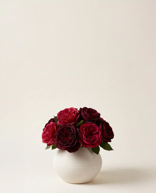 Bouquet artificiel de roses bordeaux dans un vase en céramique
