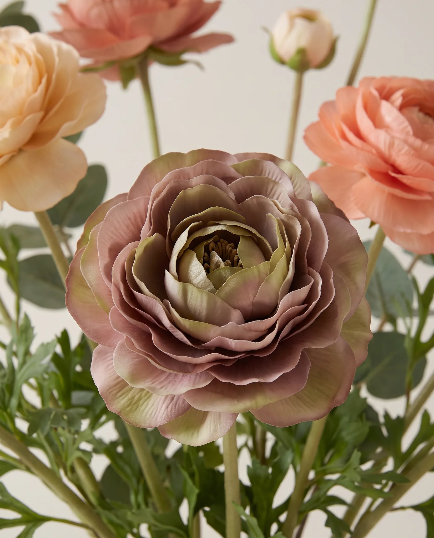 Gros plan sur les renoncules artificielles colorées du bouquet Confettis