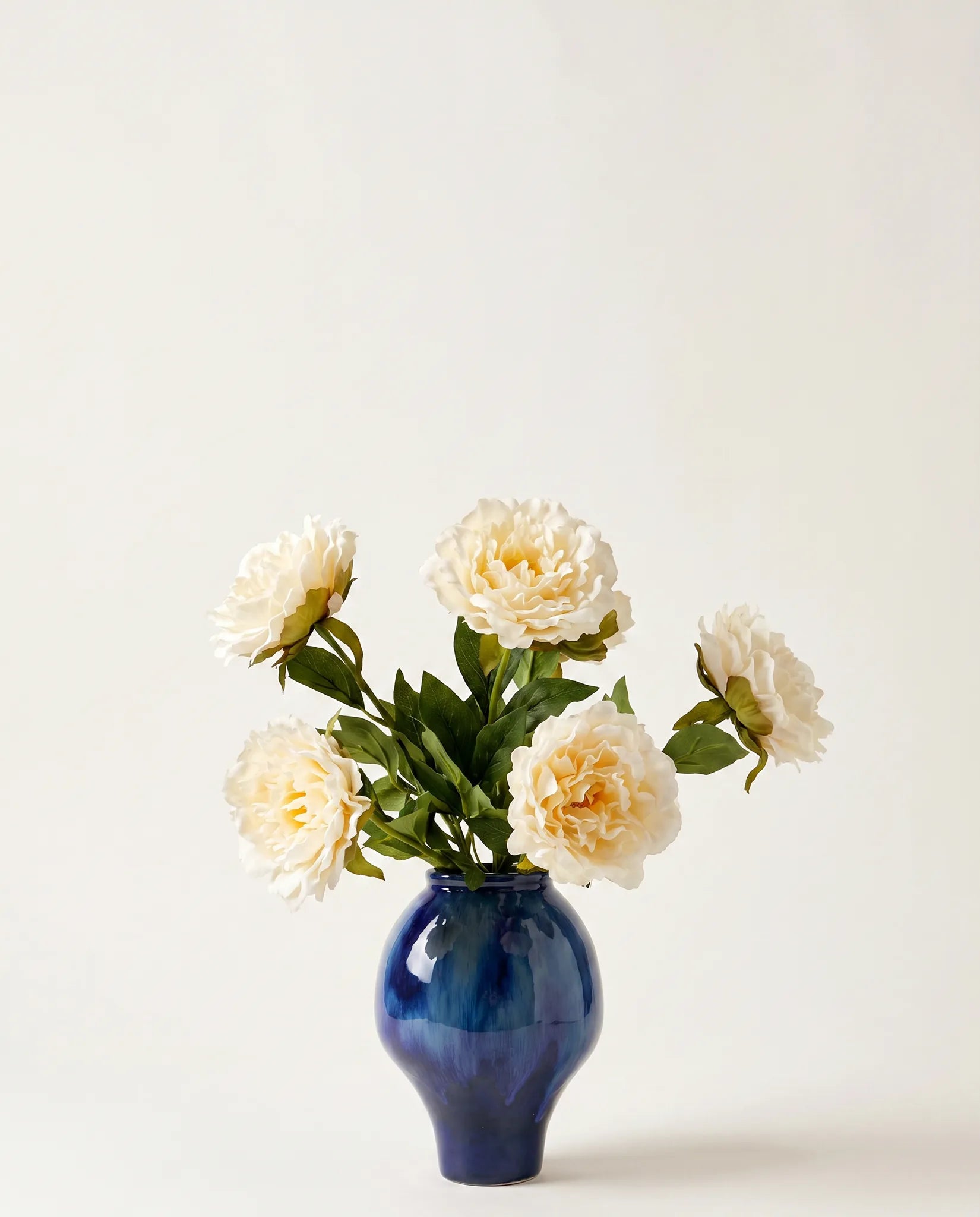 Vase céramique émaillé bleu nuit avec bouquet de pivoines blanches artificielles