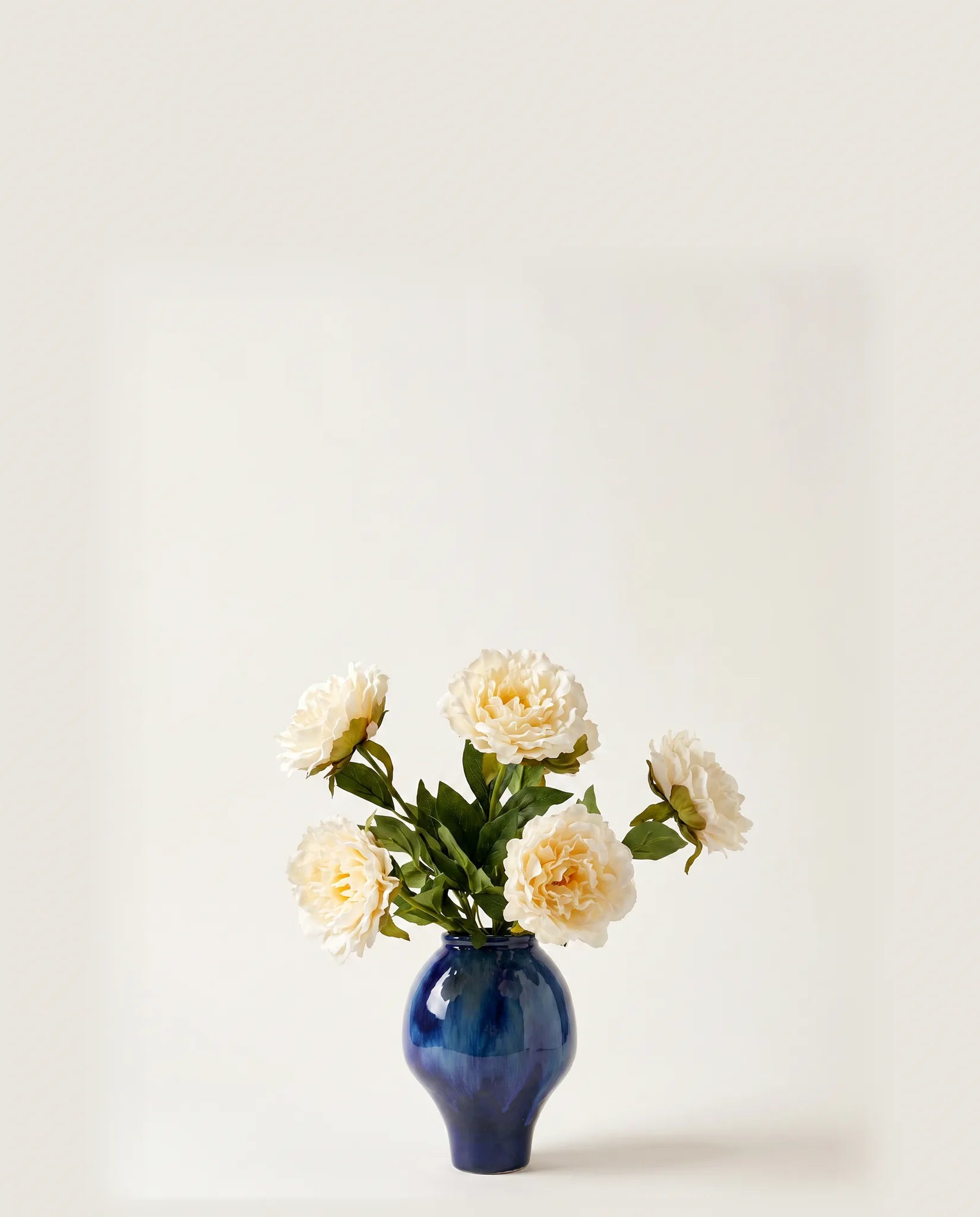 Bouquet artificiel de pivoines blanches dans un vase en céramique
