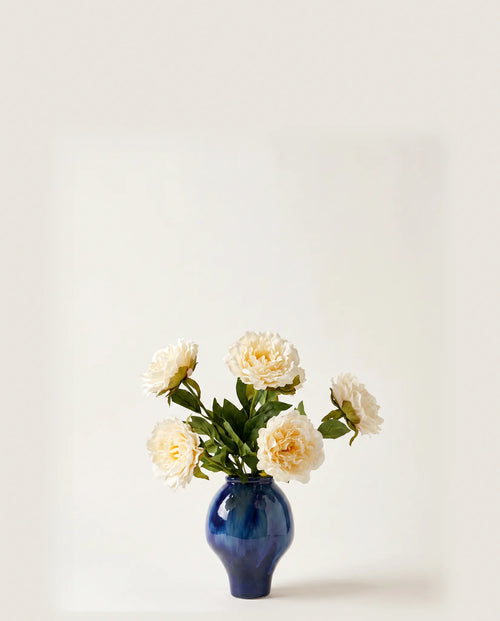 Bouquet artificiel de pivoines blanches dans un vase en céramique