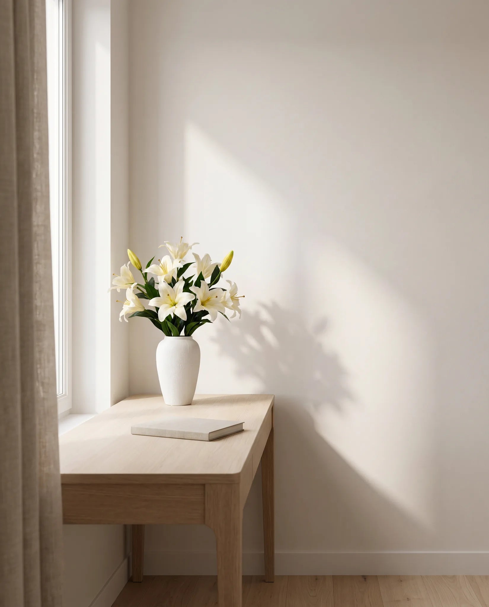 Bouquet artificiel blanc dans un bureau, table en chêne clair et rideau en lin