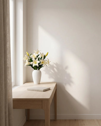 Bouquet artificiel blanc dans un bureau, table en chêne clair et rideau en lin