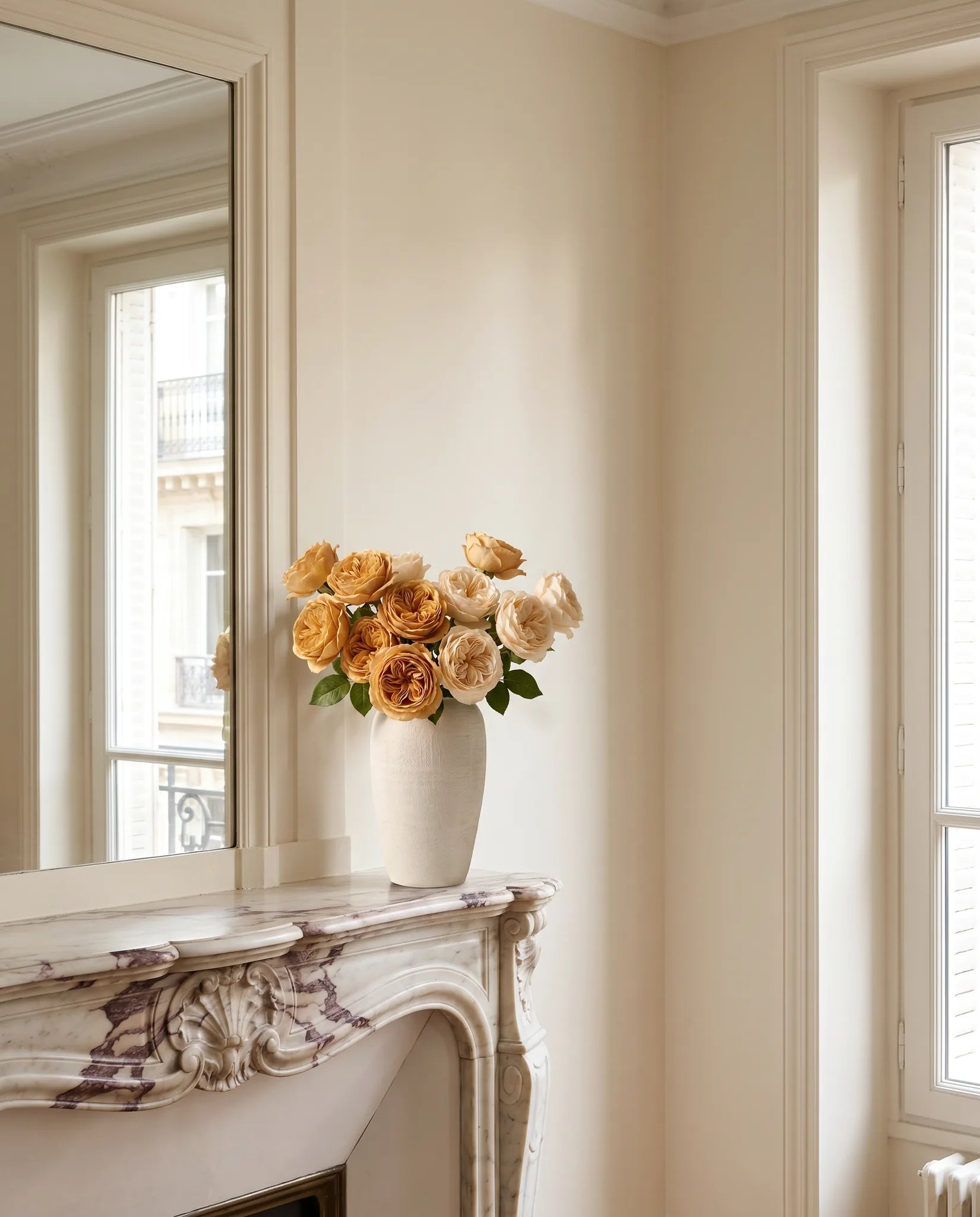 Grand bouquet artificiel champagne près d'une cheminée en marbre, salon parisien rénové