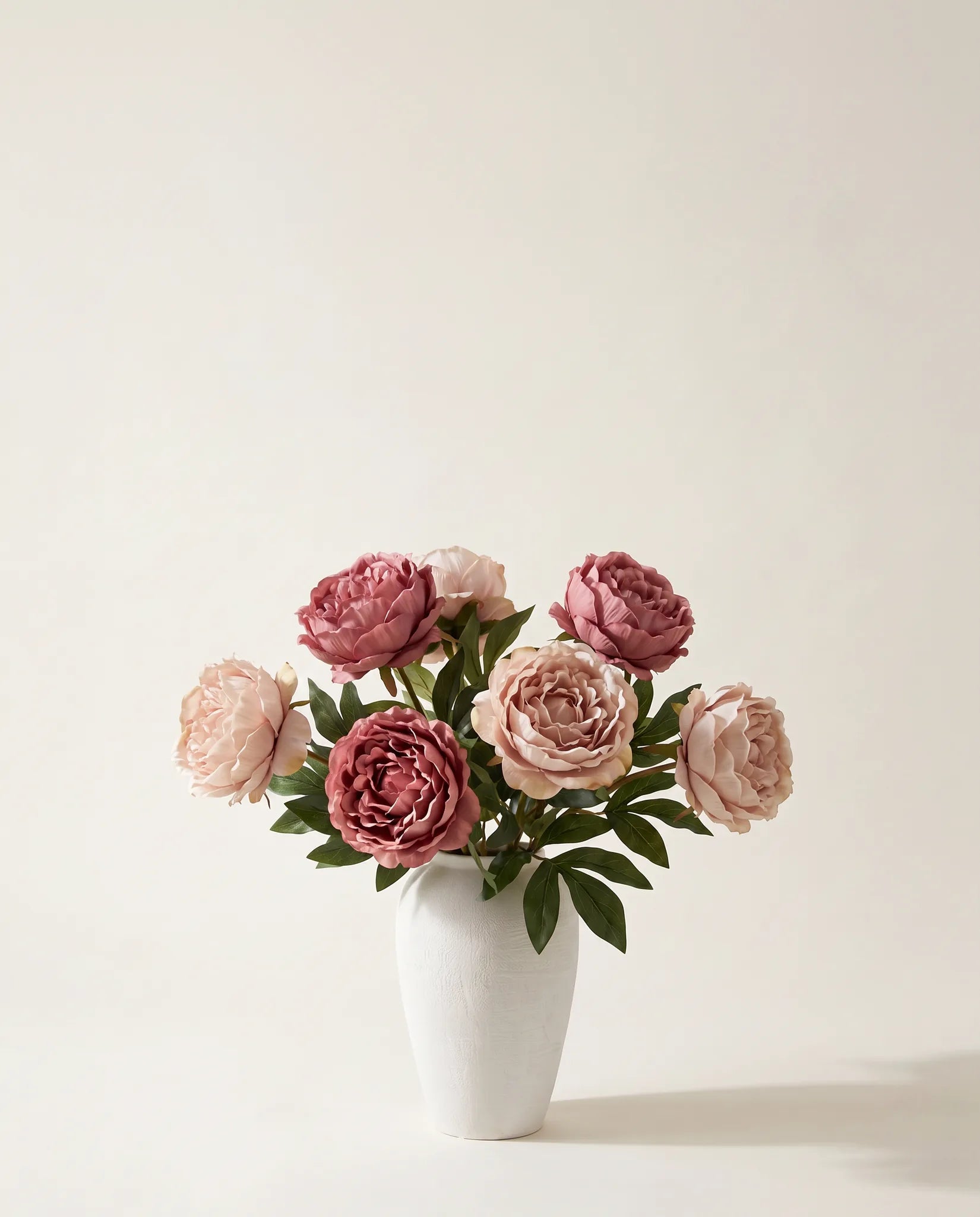 Bouquet artificiel de pivoines roses dans un vase en céramique