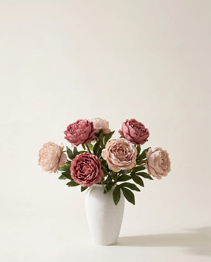 Bouquet artificiel de pivoines roses dans un vase en céramique
