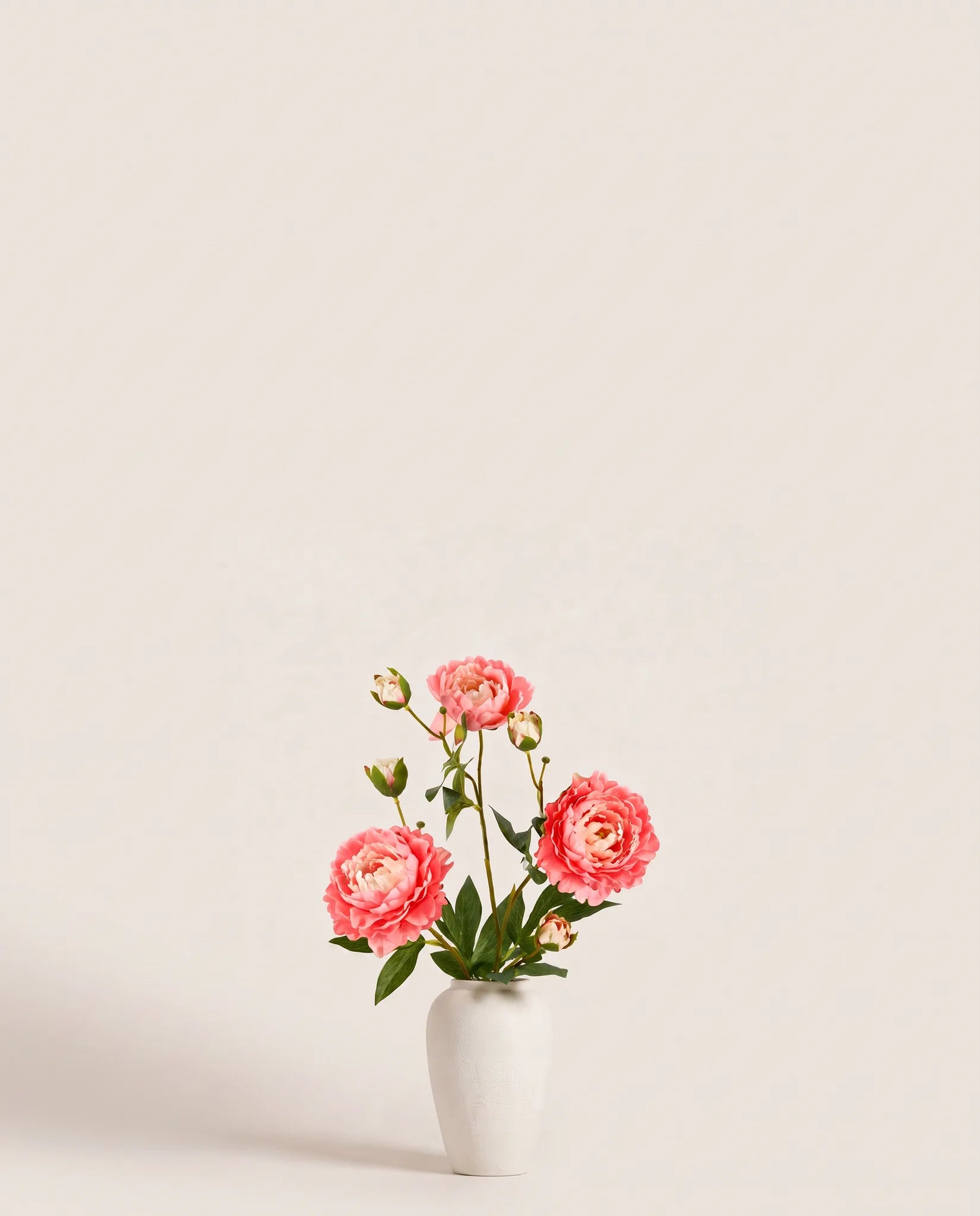 Bouquet artificiel de pivoines orange pêche dans un vase en céramique