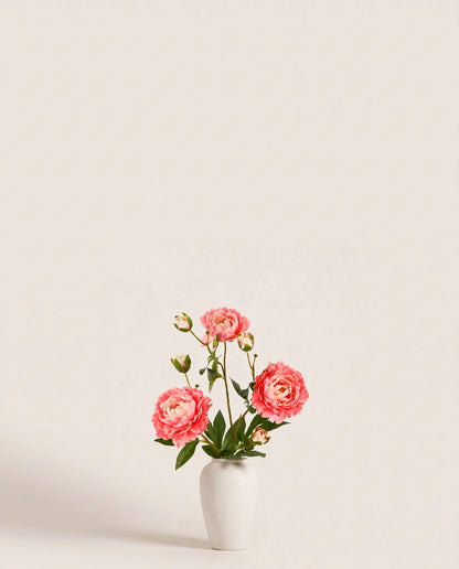 Bouquet artificiel de pivoines orange pêche dans un vase en céramique