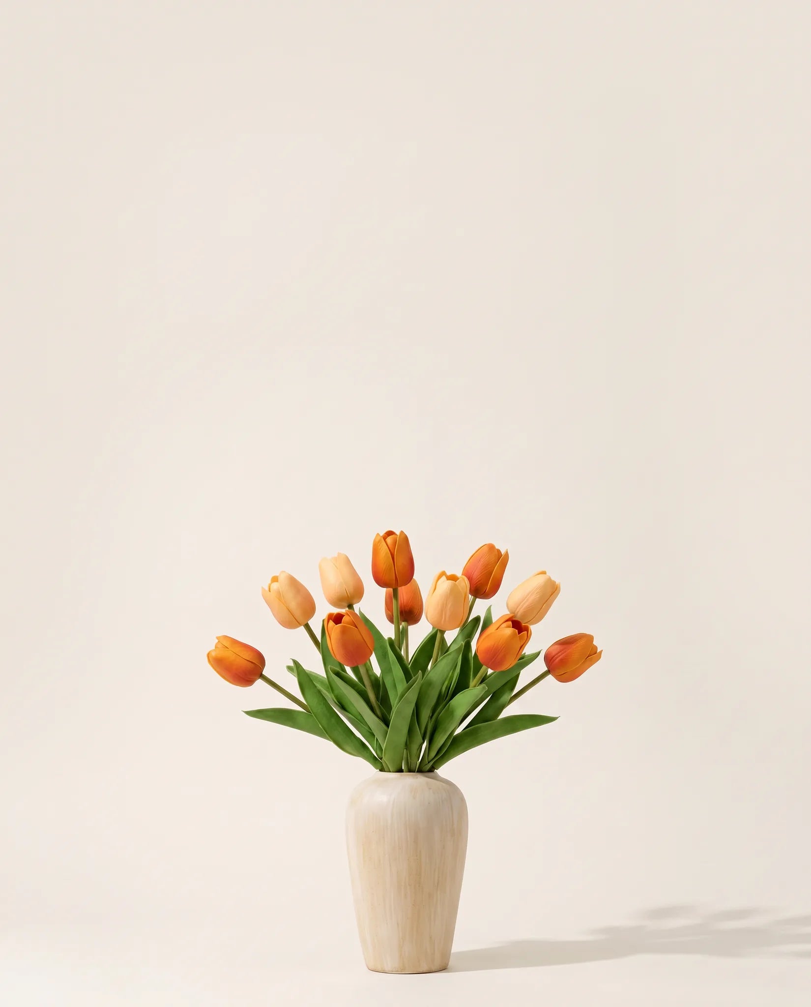 Bouquet artificiel de tulipes orange abricot dans un vase en céramique
