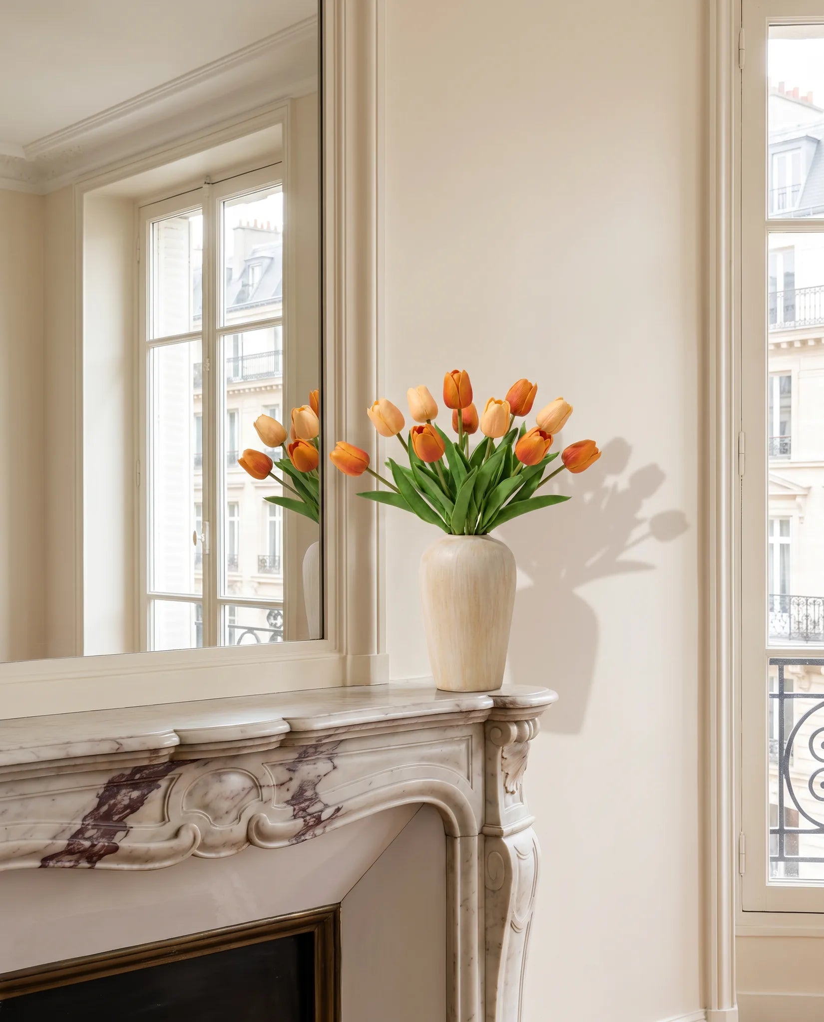 Bouquet artificiel orange abricot sur une cheminée en marbre, salon parisien