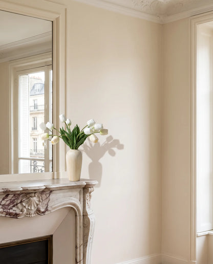 Bouquet artificiel blanc devant le grand miroir d'un salon parisien rénové