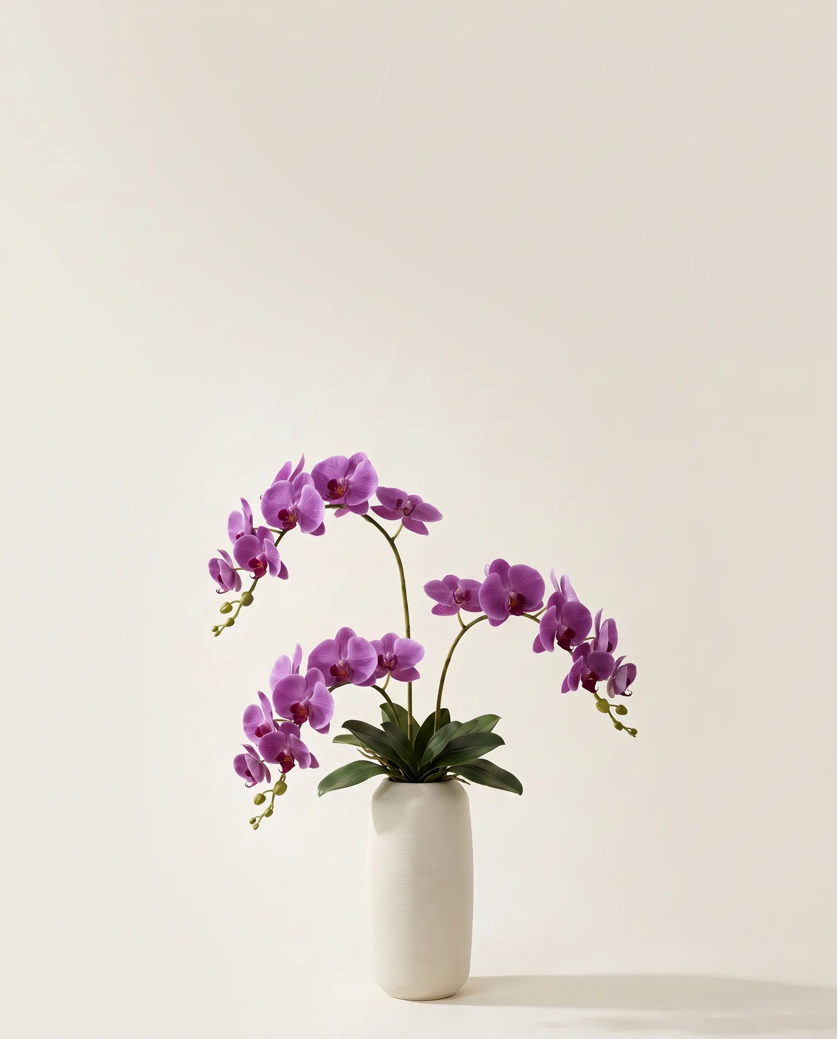 Bouquet artificiel d'orchidées violettes dans un vase en céramique