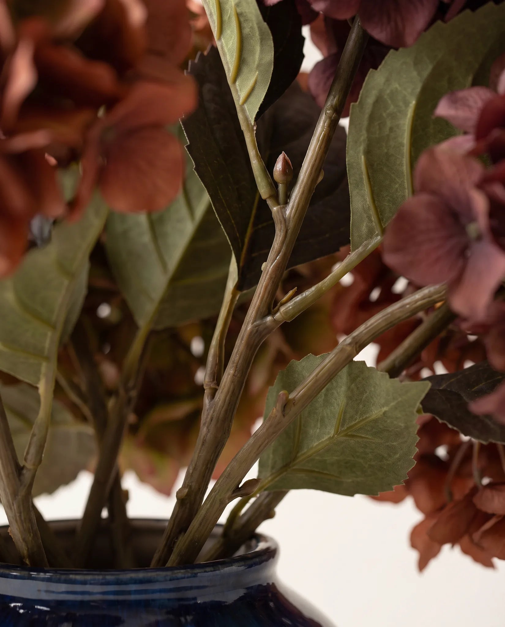 Détail des feuilles et des tiges du bouquet artificiel Braise Rouge