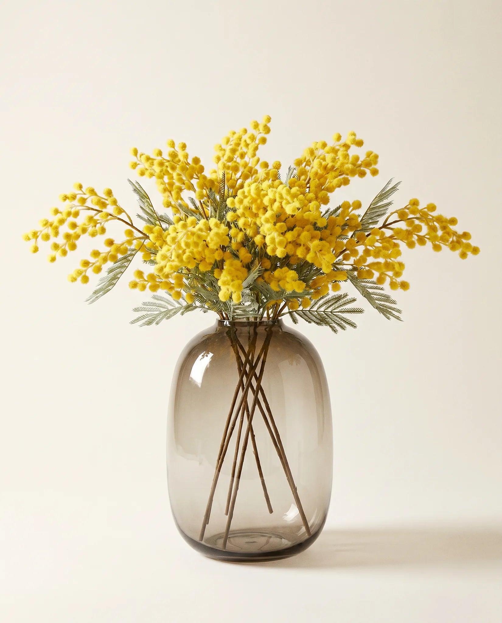 Bouquet artificiel de mimosa jaune aux feuilles gris-vert en gros plan