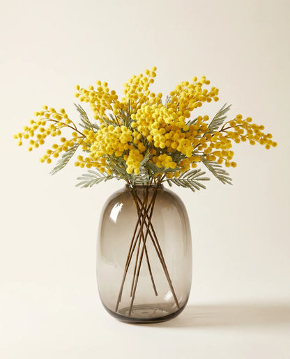 Bouquet artificiel de mimosa jaune aux feuilles gris-vert en gros plan