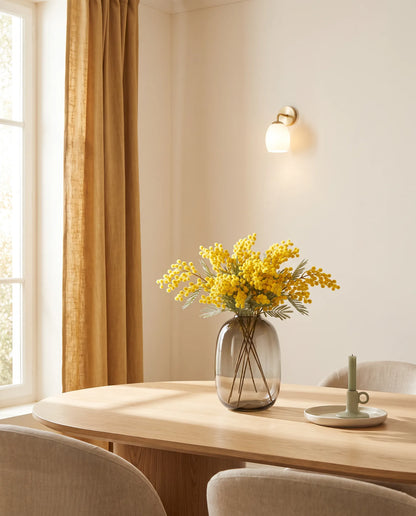 Bouquet artificiel jaune sur une table ovale en chêne clair, salle à manger beige