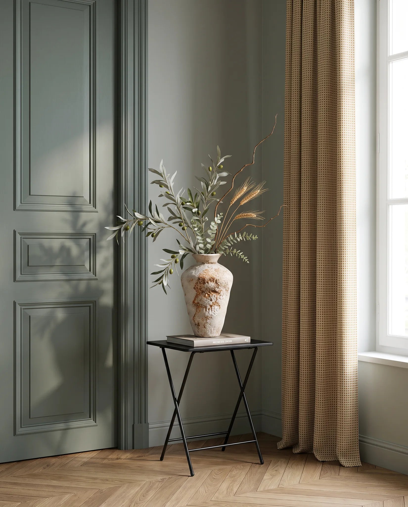 Branchage artificiel vert-olive et doré sur une table d'appoint noire dans une entrée au parquet point de Hongrie